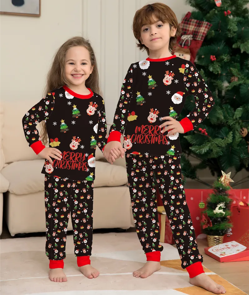 Deux enfants en pyjamas de Noël assortis devant le sapin